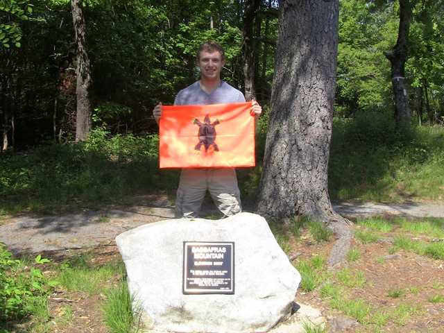 Sassafras Mountain summit boulder and plaque in green woods