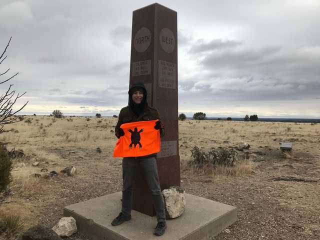 Granite obelisk on Black Mesa under gray skies