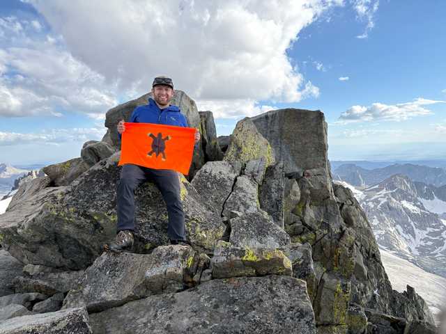 Summit boulders on Gannett Peak with snowy Wind River peaks behind