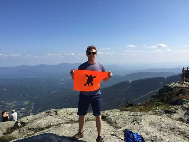 Bare rock summit of Mount Mansfield above green valleys