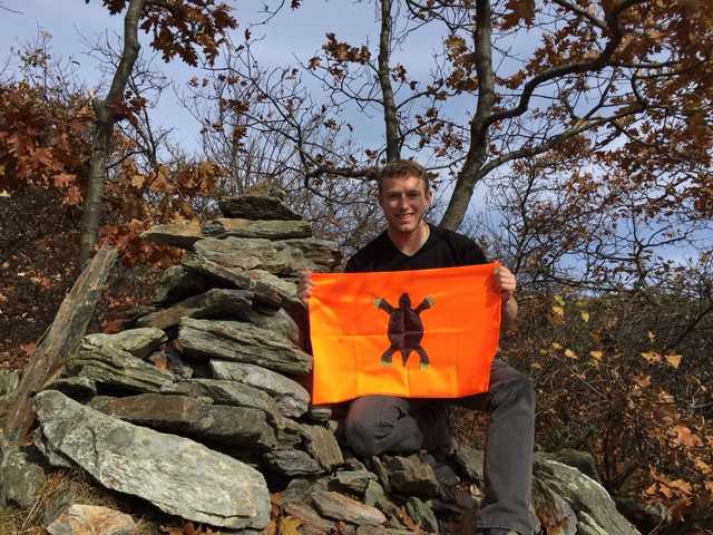 Stone cairn amid fall foliage on Mount Frissell, Justin kneeling beside it