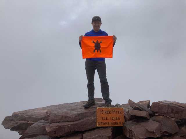 Summit rocks and sign on Kings Peak in the clouds